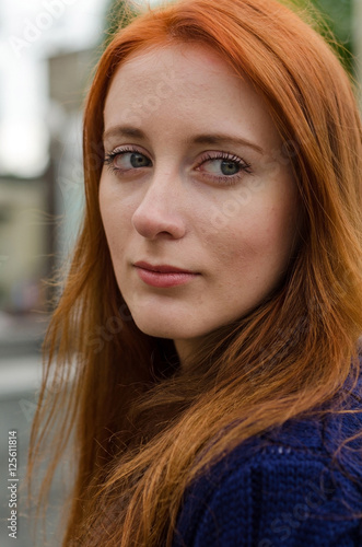 Young red woman walking in the city