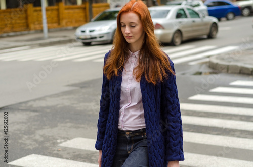 Young red woman walking in the city