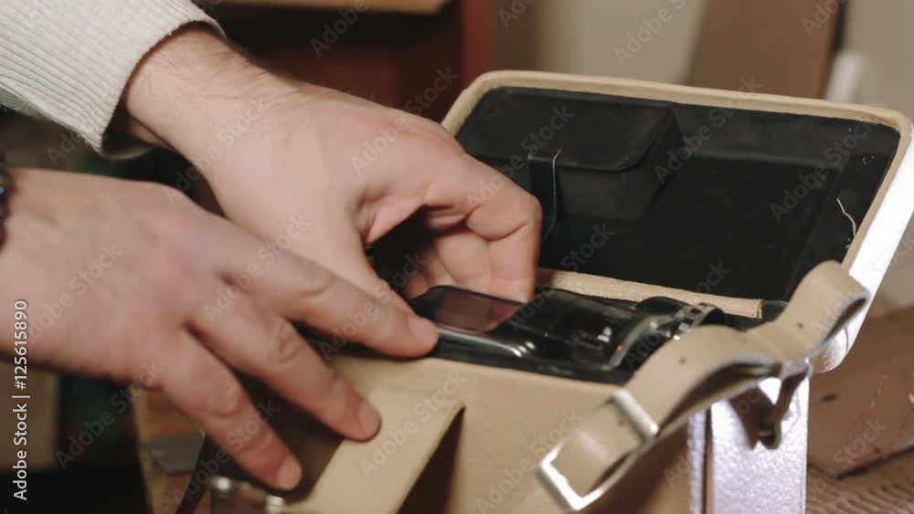 Man open bag and pulls out 8mm old film camera Man open bag and pulls out 8mm old film camera