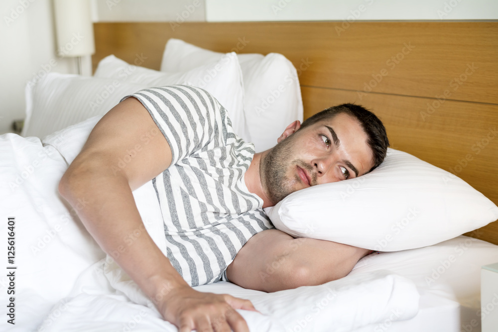 Handsome young man happily sleeping in white bed Handsome young man happily sleeping in white bed