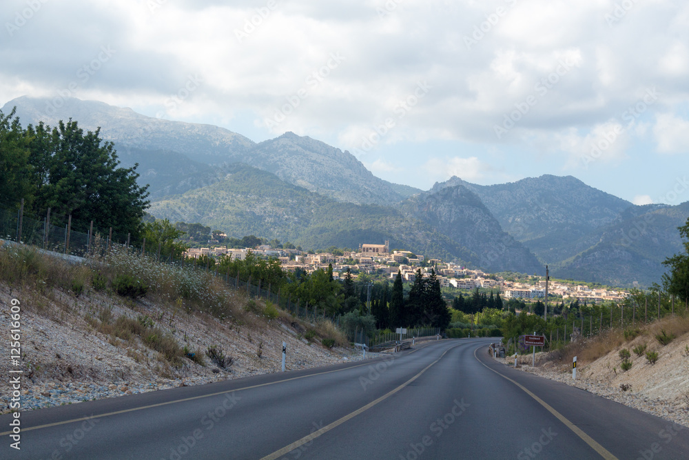 Empty road to a town in mountains Empty road to a town in mountains