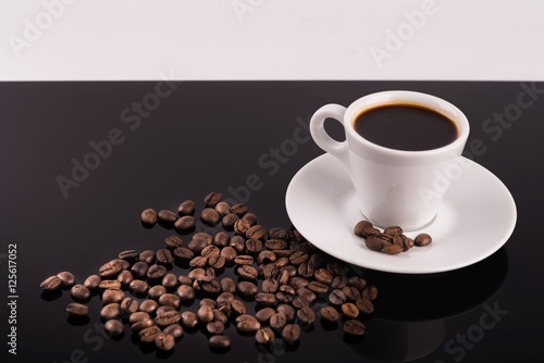 Coffee cup with coffee beans surrounding 