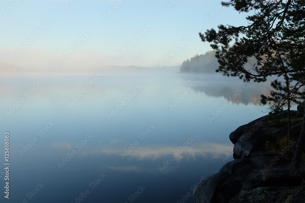 Beautiful lake view in early morning light and mist on lake surface, Finland. Beautiful lake view in early morning light and mist on lake surface, Finland.