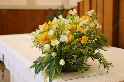 Fototapeta Naklejka Na Ścianę i Meble -  vase of beautiful flowers on the altar in the church