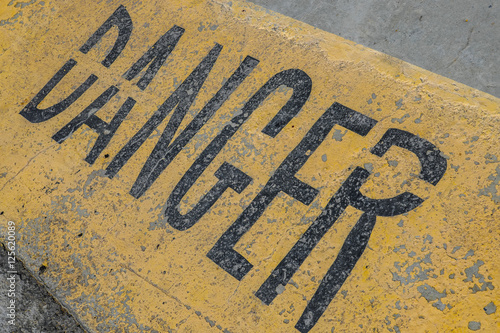 Danger sign on concrete with yellow background