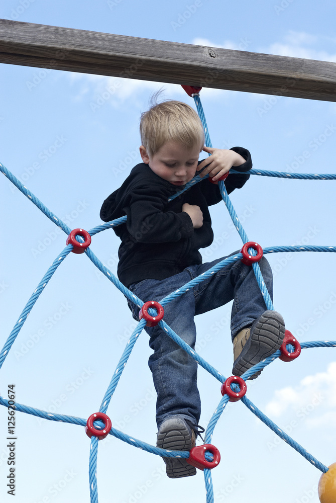 Little child blond boy climbing rope on the playground outdoors
Little child blond boy climbing rope on the playground outdoors