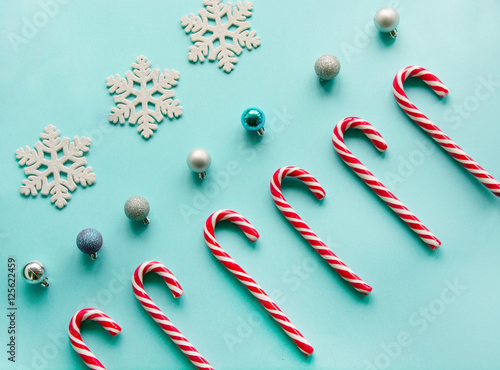 Christmas candy cane lied evenly in row on blue background. Flat lay and top view photo