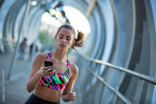 Athletic young woman using her mobile phone and listening to music for exercising. 

Workout apps are very popular nowadays because it's like having your personal trainer wherever you are.