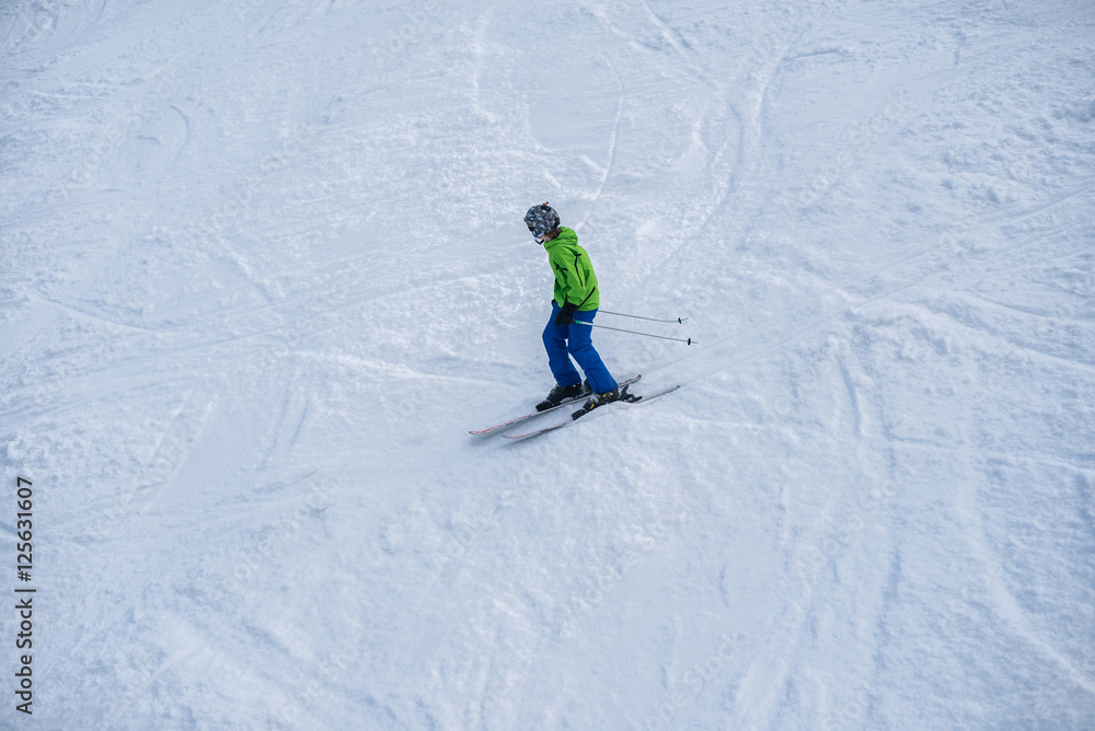 Young boy skiing down the mountain slope.