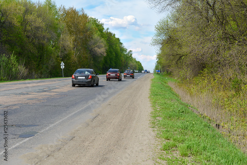 cars on the road in a wooded area