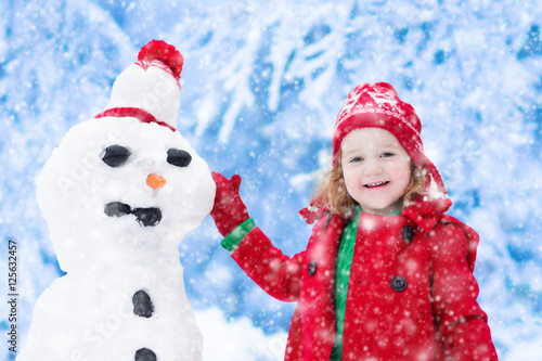 Little girl building a snow man