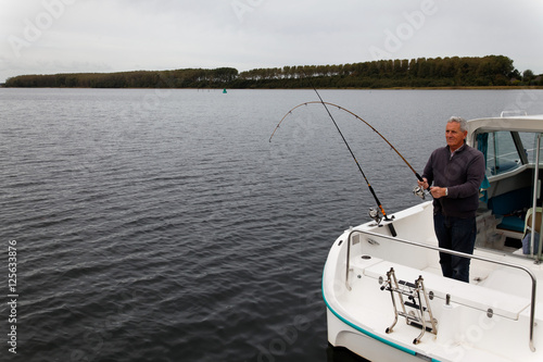 fisherman is fishing on a dark lake