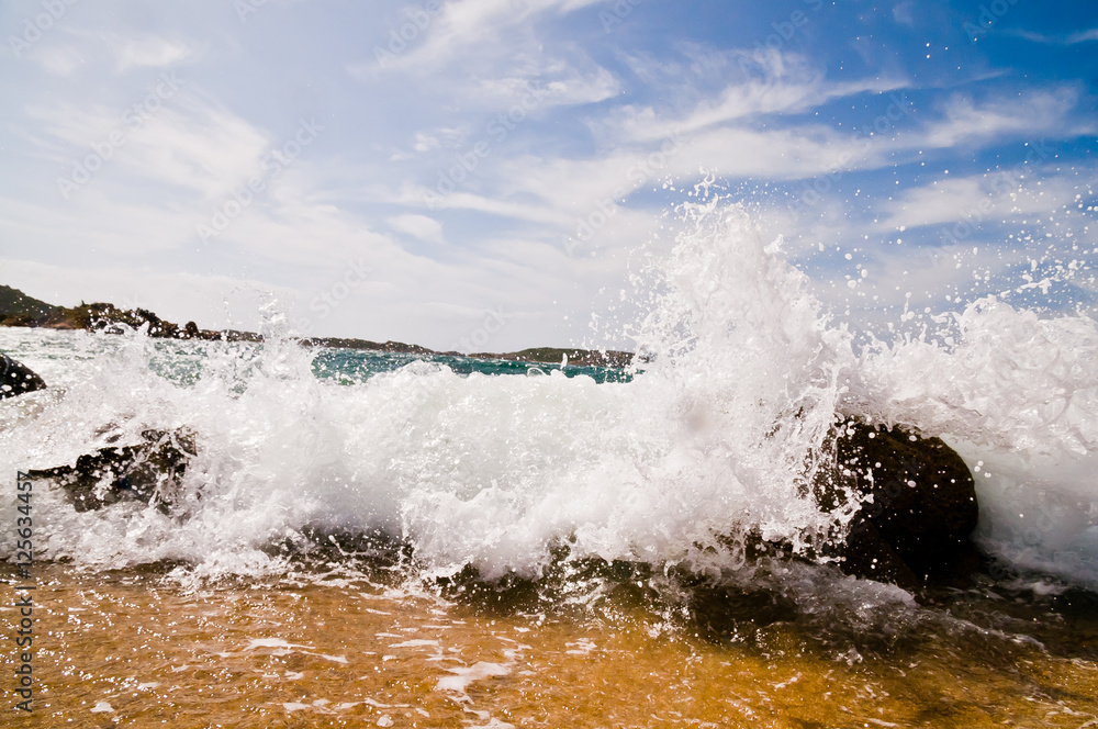 Obraz premium Wave breaking on the sea shore in Sardegna, Italy