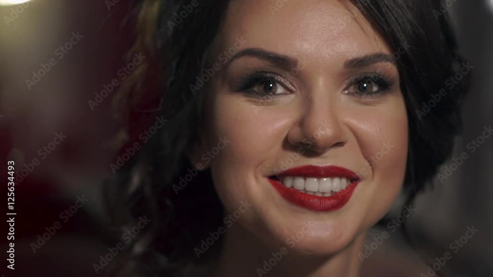 Portrait of amazing beautiful girl with red lips close-up. Happy woman smiling snow-white smile. On the edges of the frame floats tender bokeh. Portrait of amazing beautiful girl with red lips close-up. Happy woman smiling snow-white smile. On the edges of the frame floats tender bokeh.