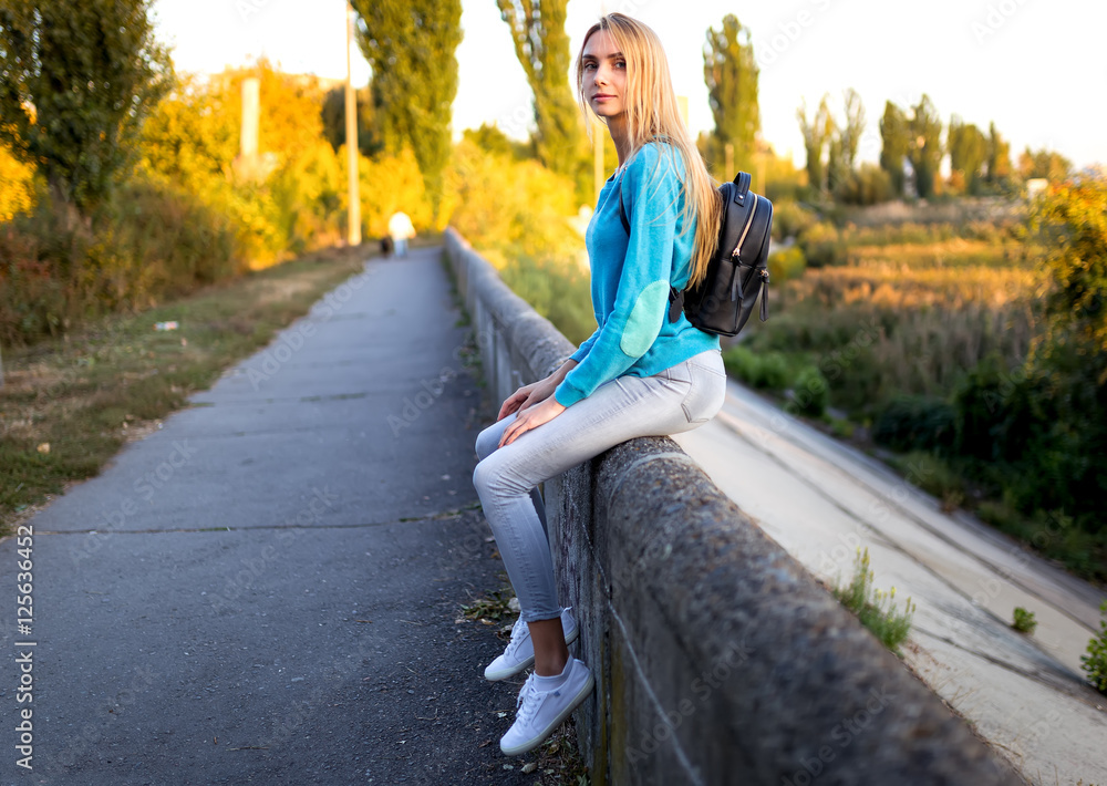 stylish girl with a backpack sitting