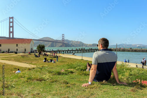 young man enjoying time and famous sightseeing in san francisco - golden gate bridge