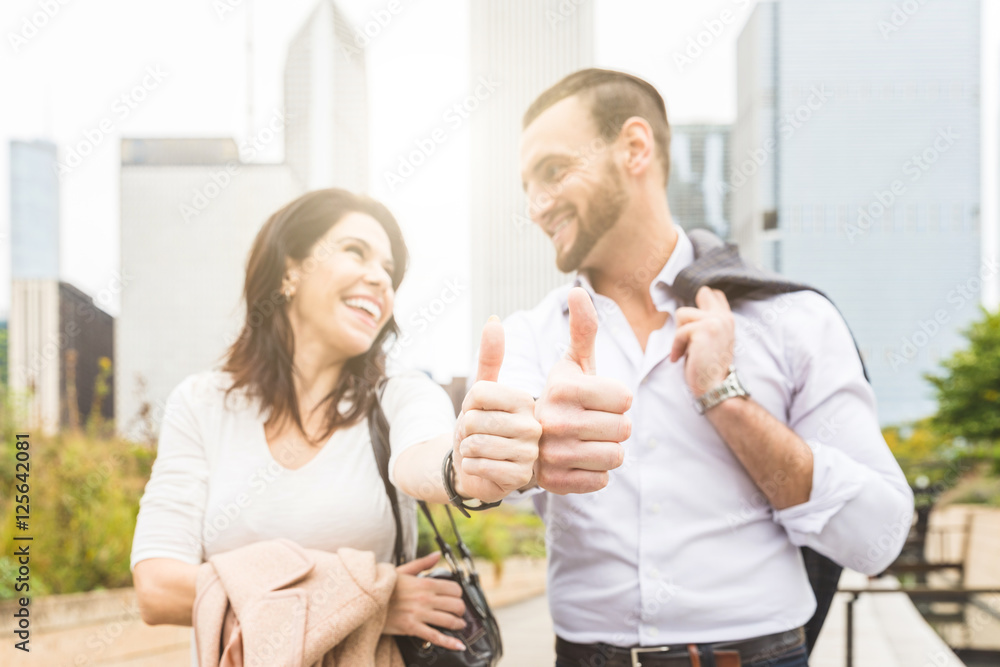 Successful business couple showing thumbs up