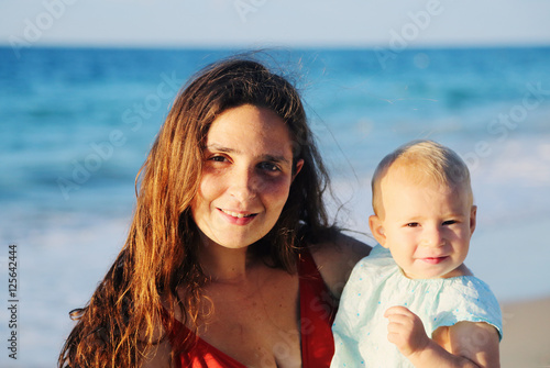 Portrait of happy loving mother and her baby at the beach