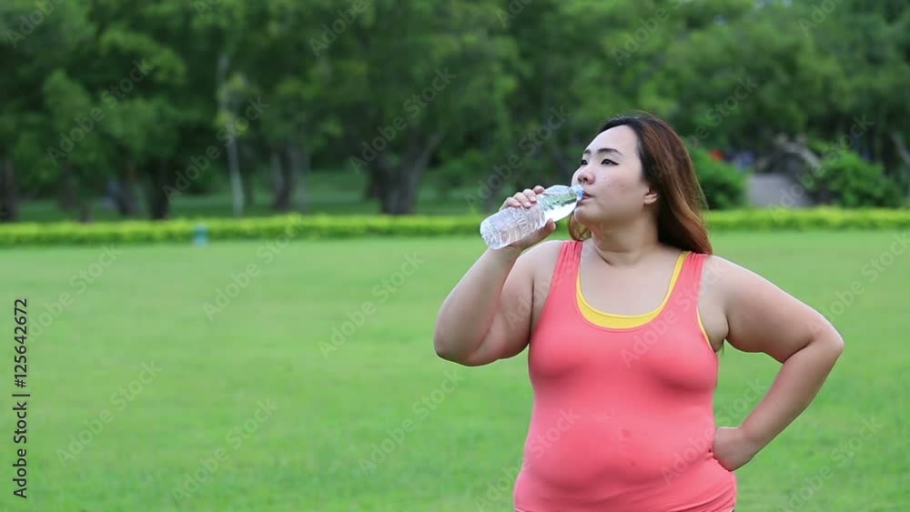 Beautiful fat woman drinking water after finish her workout. Beautiful fat woman drinking water after finish her workout.