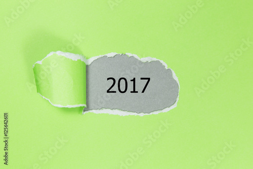 Year 2017 appearing behind ripped paper.