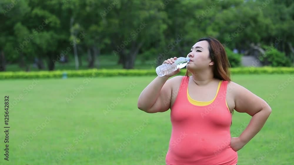 Beautiful fat woman drinking water after finish her workout. Beautiful fat woman drinking water after finish her workout.