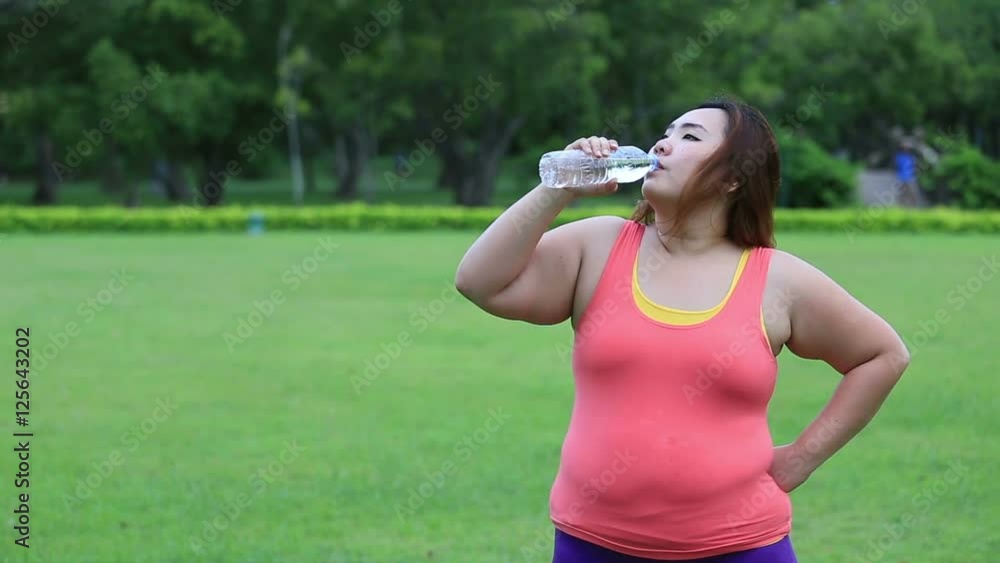 Beautiful fat woman drinking water after finish her workout. Beautiful fat woman drinking water after finish her workout.