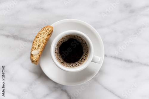Overhead view of black coffee cup and saucer on marble