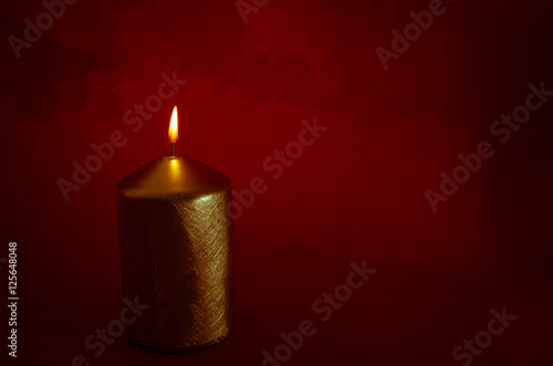 burning candle with dark red background