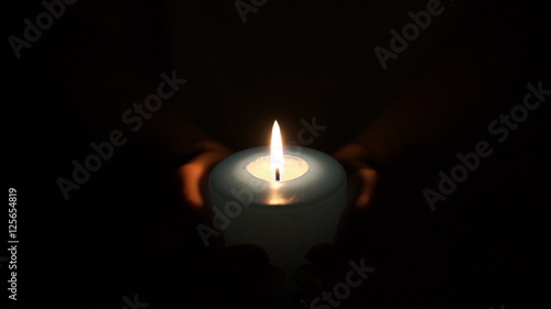 burning candle in the hands of women.