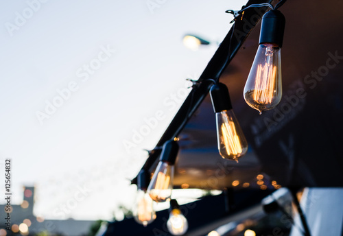 Vintage antique hanging light bulbs at a street food market. Holidays and business good idea concept.