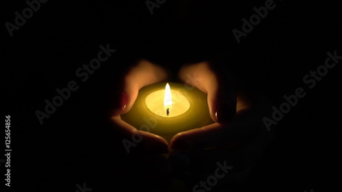 burning candle in the hands of women.