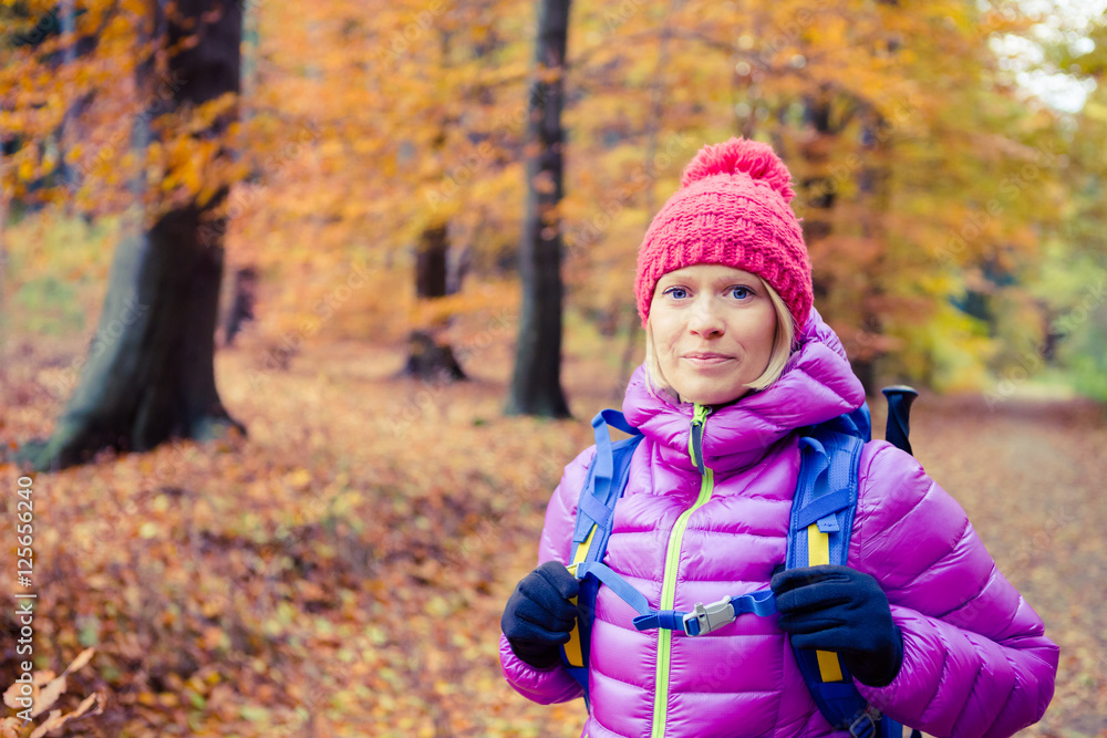 Hiking woman with backpack looking at camera in inspiring autumn Hiking woman with backpack looking at camera in inspiring autumn