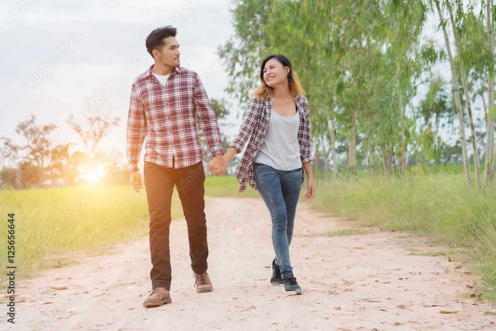 Young couple in love walking on rural road holding hands talking Young couple in love walking on rural road holding hands talking