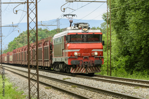 Red locomotive towing a freight train