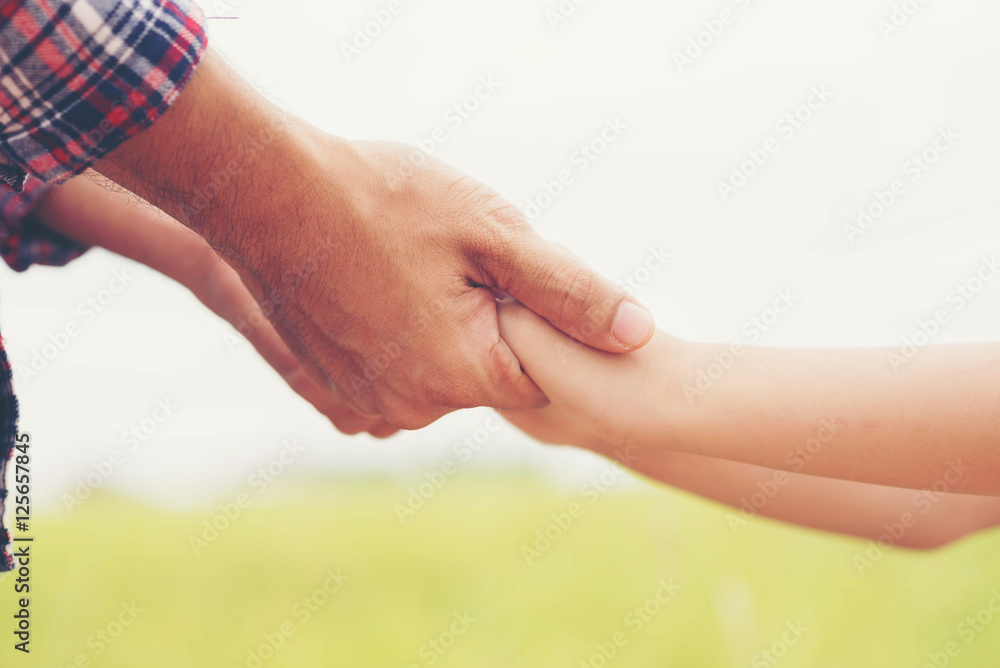 Portrait of Father and daughter holding hand in hand on field. Portrait of Father and daughter holding hand in hand on field.
