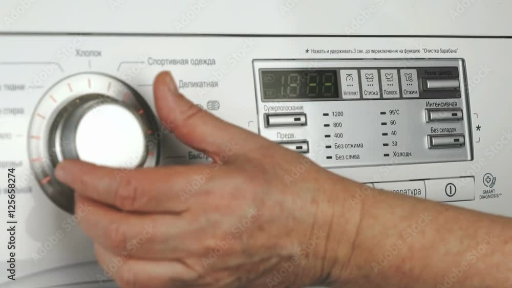 Woman selects program of wash of washing machine Woman selects program of wash of washing machine
