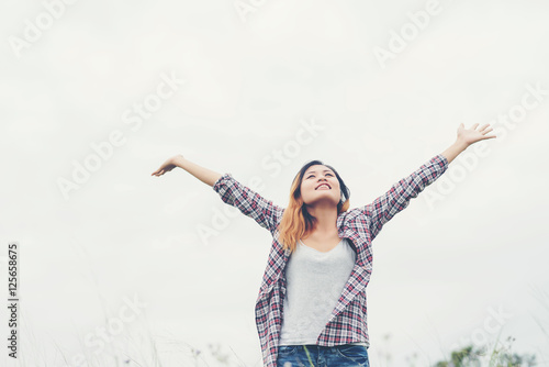 Young woman spreading hands with joy with nature.