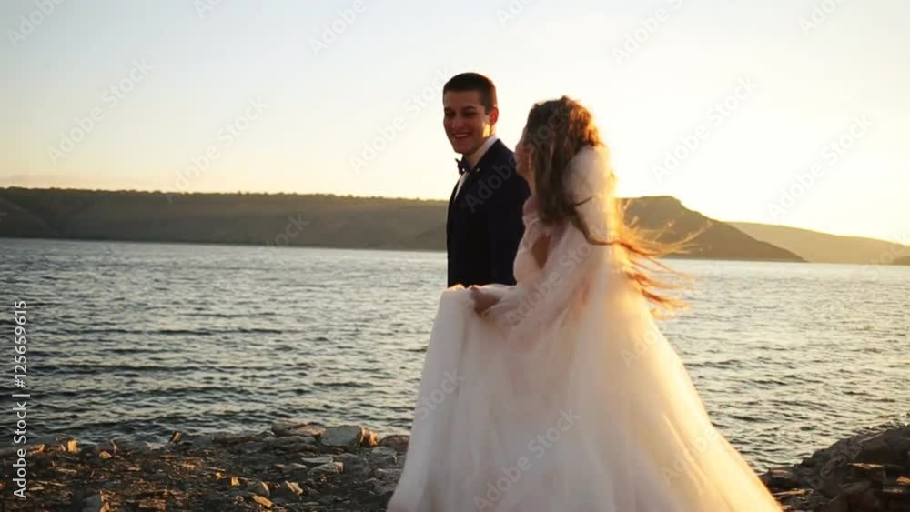 Happy gorgeous smiling bride running and having fun with elegant groomat mountains with amazing view. Happy gorgeous smiling bride running and having fun with elegant groomat mountains with amazing view.