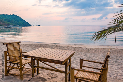 Table and chairs in the sunrise at a tanquil beach in Thailand