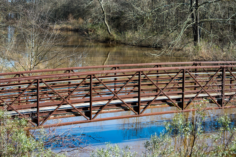 Trail bridge over small creek leading to Lake Crabtree in North Carolina. Greenway.