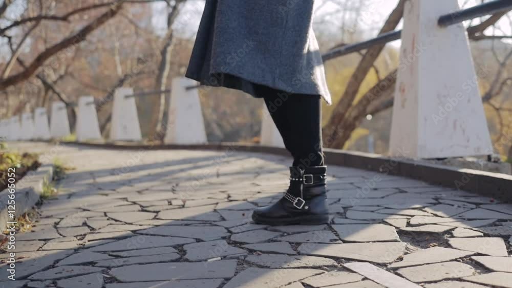 Fall, autumn, leaves, legs and shoes. Legs in boots on the street with leaves . Feet shoes walking in nature Fall, autumn, leaves, legs and shoes. Legs in boots on the street with leaves . Feet shoes walking in nature