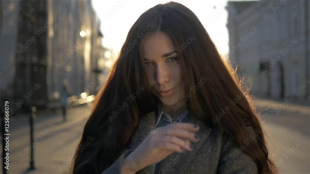 Pretty mixed race woman walking on autumm street on the sunset background - Beautiful girl walking outdoors in old europe. Pretty mixed race woman walking on autumm street on the sunset background - Beautiful girl walking outdoors in old europe.
