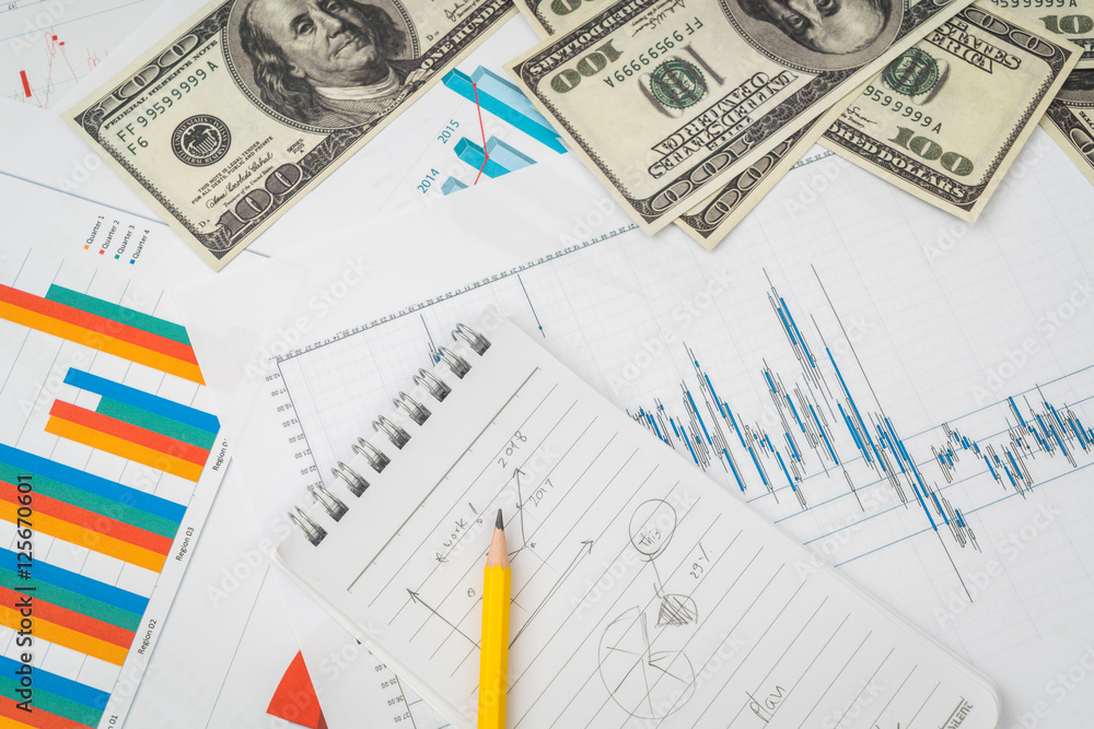 Financial charts on the table with dollars banknotes . Financial charts on the table with dollars banknotes .