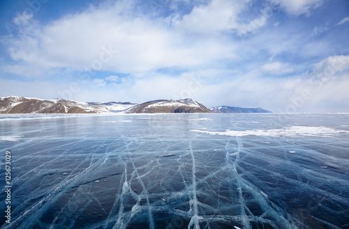 Winter ice landscape on Siberian lake Baikal with clouds