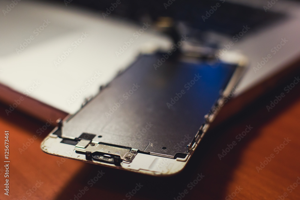 A close-up process of disassemble and dismantle modern mobile phone smartphone with broken shattered display glass and changing details at home A close-up process of disassemble and dismantle modern mobile phone smartphone with broken shattered display glass and changing details at home