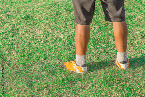 legs of walking man on grass