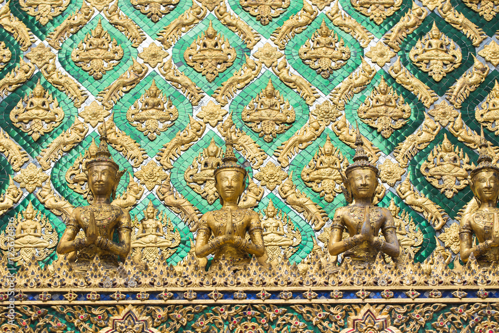 Thai antique art decoration buddhist temple wall, golden angle wallpaper for background background design.