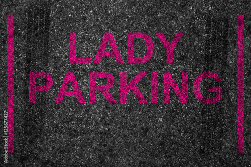 reserved car park slot with paint text word lady parking, woman driver driving stop space