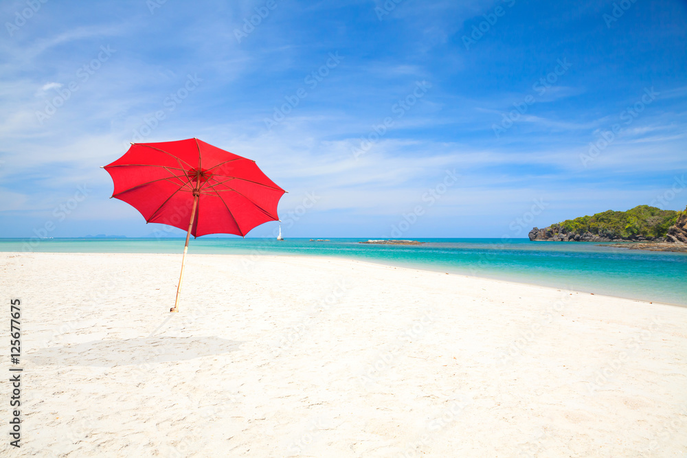 Red beach umbrella with sky background