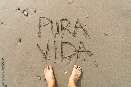 Pura Vida message on the beach sand